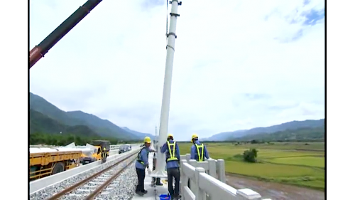 系統機電工程係配合土建施工進度，進場架設電車線、號誌、照明及電訊等施工，包含變電站工程號誌系統與電車線系統。【圖/架設電車線作業】