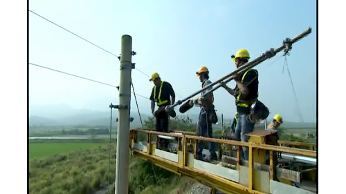 系統機電工程係配合土建施工進度，進場架設電車線、號誌、照明及電訊等施工，包含變電站工程號誌系統與電車線系統。【圖/架設電車線作業】