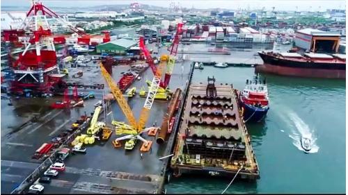 由銘榮元公司負責承製首支離岸風電的國產鋼管樁運抵高雄港75號碼頭，裝載至平台運輸船。