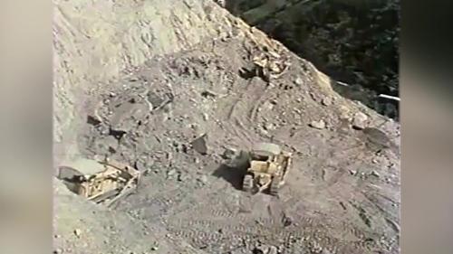 &nbsp;岩石炸鬆後，由重型推土機將以炸鬆的岩石由內向外逐層向邊坡推落，然後再開始次一階的預裂與爆破孔的鑽孔，如此逐階下降直至河底最下一階為止。