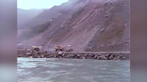 &nbsp;岩石炸鬆後，由重型推土機將以炸鬆的岩石由內向外逐層向邊坡推落，然後再開始次一階的預裂與爆破孔的鑽孔，如此逐階下降直至河底最下一階為止。