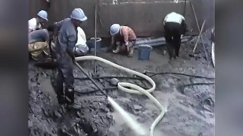 為使混凝土與岩石間有良好的結合，岩石面上需潔淨無塵，本工程就以每平方公分7公斤壓力的水槍噴洗，局部岩面上黏著岩垢水力沖洗不掉時，更以鋼刷洗刷，務使達到要求的潔淨程度。