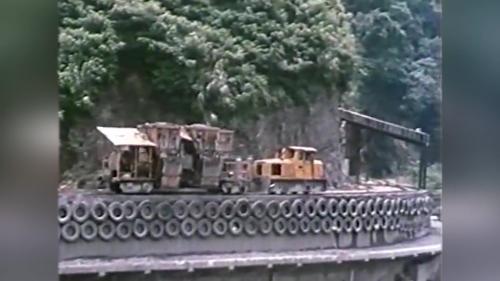 &nbsp;混凝土於拌合後，卸裝於特製火車承載斗中，由火車沿專用平台，將混凝土運到索道吊車懸吊的吊桶旁，將混凝土自動卸入吊桶中，每一吊桶可裝載4.5立方公尺混凝土，吊桶升高後沿索道橫移到大壩混凝土澆置位置。