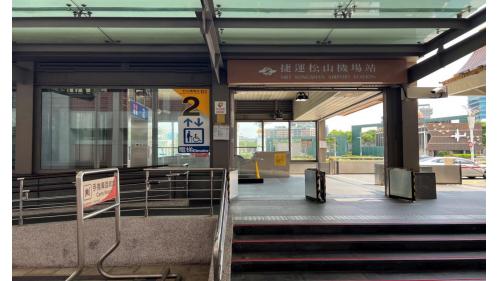 松山機場站位於敦化北路上，松山機場站為地下四層車站，設3處出入口，地下一樓為連通層，地下二樓為大廳層;地下三樓為夾層，地下四樓為月台層，設有一座島式月台及全高式月台門。【圖/臺北捷運松山機場站2號出口-第二航廈西側】