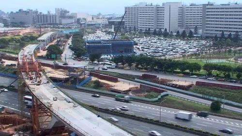 長庚醫院站到林口站之間，為跨越中山高速公路之景觀橋，由三跨連續漸變斷面預力箱型梁，配合兩座V型橋墩組合，基礎為井筒型式基腳。 V型橋墩中間之上構以重型施工支撐方式施作，外伸部分則採用場鑄懸臂法施工。【圖/ V型橋墩施作】