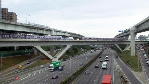 長庚醫院站到林口站之間，為跨越中山高速公路之景觀橋，由三跨連續漸變斷面預力箱型梁，配合兩座V型橋墩組合，基礎為井筒型式基腳。橋墩中間之上構以重型施工支撐方式施作，外伸部分則採用場鑄懸臂法施工。【圖/列車經過V型橋交會】