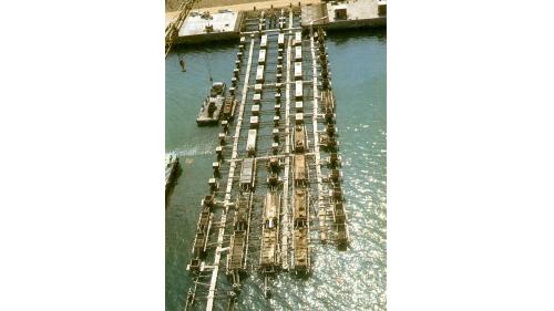 吉達軍港港灣碼頭工程由榮工處承辦，派特拉公司承辦機電與軍事設備之採購及安裝，於1975年2月開工，1979年6月完成。【圖/吉達軍港突堤碼頭有如航空母艦跑道舺舨】