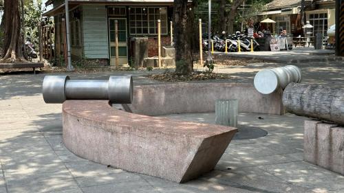 &nbsp;橋頭糖廠站為地下一層地上二層車站，一樓為大廳層及出入口，設有公共藝術『歷史的三個孩子－一種場域躍動的美學』。主體材料以高雄百年窯場「三和瓦窯」燒製的紅磚碎片，重新 凝聚鑄造而成。主體三元件採凹凸陰陽相互補，形成暗喻時間軌 跡式的可乘坐台面，塑造文化意涵的場域，並創造站前廣場一個 可親近匯集、等待對話、嬉戲溝通和記憶串聯的地景意象。【圖/公共藝術-歷史的三個孩子－一種場域躍動的美學。作者：顏名宏】