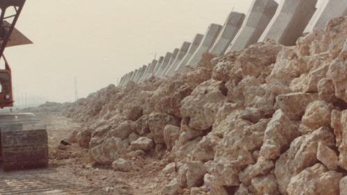 1978年8月興達電廠由榮工處承建，榮民員工將大量的咾咕石先填築於海堤處，穩固海岸後再建立圍堤。