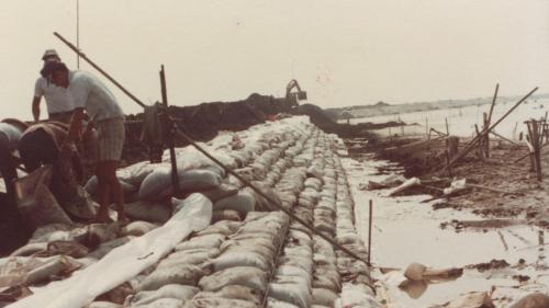 1978年8月興達電廠由榮工處承建，榮民員工將大量的咾咕石先填築於海堤處，穩固海岸後再建立圍堤。