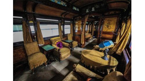 天皇花車主室內的菊花瓣家徽抱枕沙發，左上為知名畫家川端玉章的四季花卉圖。